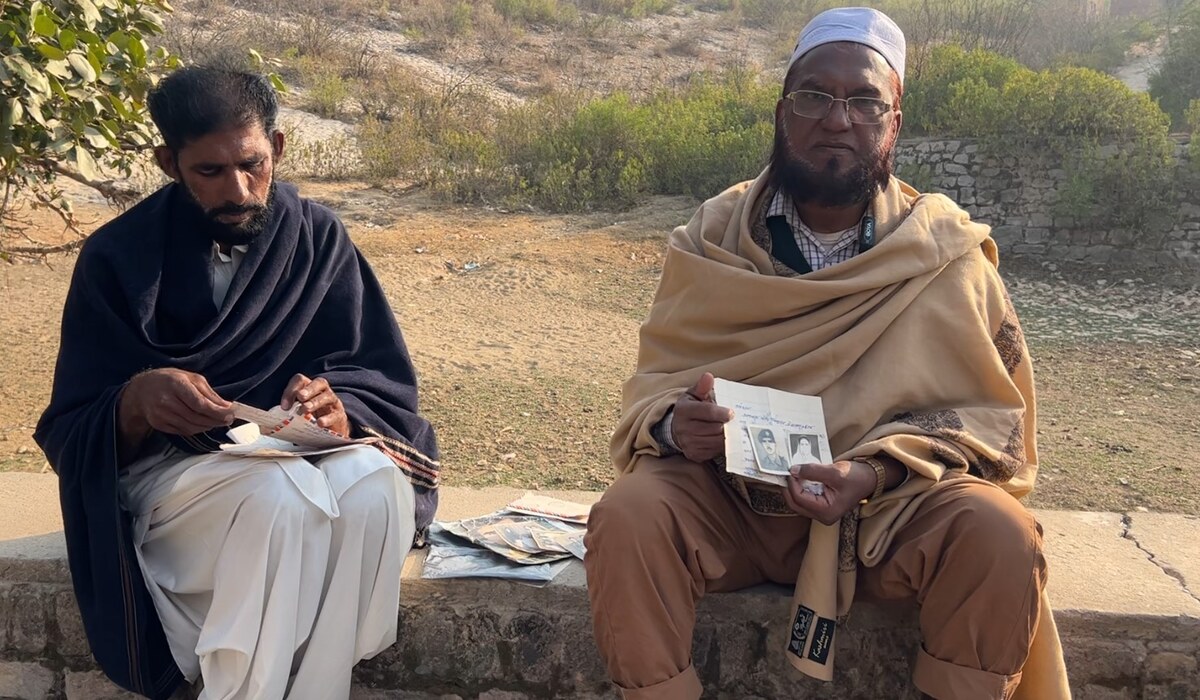 iftikhar_hussain_shows_photographs_of_his_father_abdul_rauf_and_mother_munawara_begum_as_he_visits_his_fathers_home_in_chakwal_district_of_punjab_pakistan_on_january_30_2025.jpg